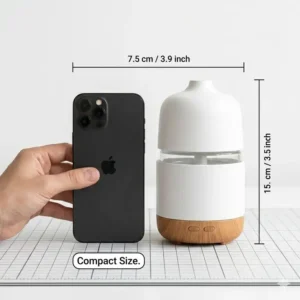 Side-by-side comparison of a compact liquid incense burner next to a smartphone for scale.