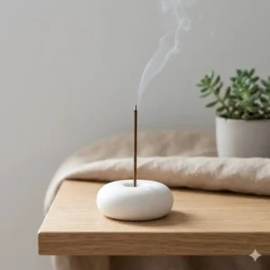A minimalist white ceramic holder displaying a single stick of incense and incense holders set.