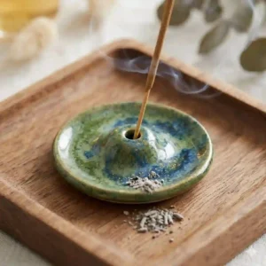 Close-up of a handmade ceramic incense tray showing detailed glaze patterns and ash-catching design.